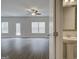 Spacious living room with wood-look floors, ceiling fan, and natural light is adjacent to a half bathroom at 4454 Eastbrook Pl # 57B, Snellville, GA 30039