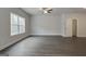 Large, open living area with wood-look flooring, neutral paint, and a connecting door to a bathroom at 4454 Eastbrook Pl # 57B, Snellville, GA 30039