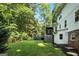 Expansive backyard featuring mature trees, a deck with a pergola, and a grassy lawn at 591 Clubwood Ct, Marietta, GA 30068