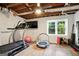 Finished basement features a home gym with exercise equipment, a window, and ceiling fan at 591 Clubwood Ct, Marietta, GA 30068