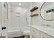 Bright bathroom featuring a tub and shower combination with modern fixtures and shelving at 591 Clubwood Ct, Marietta, GA 30068
