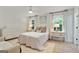 Light-filled bedroom features a soft color palette and two bedside tables at 591 Clubwood Ct, Marietta, GA 30068