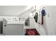 Functional laundry room featuring a washer, dryer, and clothing rack on a sloped ceiling at 591 Clubwood Ct, Marietta, GA 30068