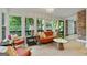 Light filled sunroom with floor to ceiling windows showcasing the beautiful wooded property at 591 Clubwood Ct, Marietta, GA 30068