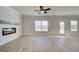 Spacious living room with a fireplace, wood flooring, large windows, and a ceiling fan at 4434 Eastbrook Pl # 59A, Snellville, GA 30039