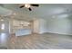 Open-concept living space with kitchen island, ceiling fan, and gray wood floors at 4434 Eastbrook Pl # 59A, Snellville, GA 30039
