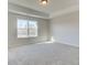 Main bedroom features a large window, neutral carpeting, and trey ceiling at 4434 Eastbrook Pl # 59A, Snellville, GA 30039