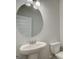 Powder room featuring a pedestal sink, round mirror, and a toilet at 4434 Eastbrook Pl # 59A, Snellville, GA 30039