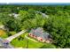 Aerial view of a home with a stone exterior and a well-manicured lawn surrounded by lush greenery at 508 College St, Bowdon, GA 30108