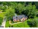 Stunning aerial view of a stone home surrounded by lush trees and a well-manicured lawn at 508 College St, Bowdon, GA 30108