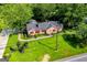 Aerial view showcasing the stone home's unique architecture and beautifully landscaped front yard at 508 College St, Bowdon, GA 30108