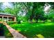 Expansive backyard featuring lush green lawn, mature trees, and covered parking at 508 College St, Bowdon, GA 30108