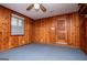 Basement features wood paneling and carpeted flooring, window and a ceiling fan at 508 College St, Bowdon, GA 30108