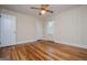 Cozy bedroom featuring wood floors, a ceiling fan, and natural light from the window at 508 College St, Bowdon, GA 30108