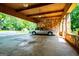 Spacious two car carport with stone walls and views of the lush green yard at 508 College St, Bowdon, GA 30108