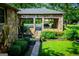 Stone carport featuring a car and mature landscaping at 508 College St, Bowdon, GA 30108