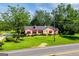 Charming stone home with red awnings, surrounded by green grass and mature trees at 508 College St, Bowdon, GA 30108