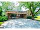 Stone house with lush green lawn and trees in the front and a large open carport at 508 College St, Bowdon, GA 30108