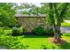 Stone-clad house showcasing verdant lawn, mature trees, and charming curb appeal at 508 College St, Bowdon, GA 30108