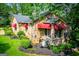 Side view showcasing stone exterior, gray roof, red awnings, landscaping and a beautiful lawn at 508 College St, Bowdon, GA 30108