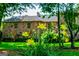 Exterior view of stone house with yellow flowers and a lush green lawn at 508 College St, Bowdon, GA 30108