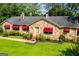 Beautiful stone house featuring unique architectural details, well-kept landscaping, and red awnings at 508 College St, Bowdon, GA 30108