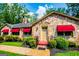 Charming stone home with red awnings and well-manicured landscaping provides great curb appeal at 508 College St, Bowdon, GA 30108
