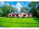 Charming stone home with bright green lawn, red awnings, and mature trees creates inviting atmosphere at 508 College St, Bowdon, GA 30108