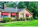 Charming stone home with red awnings and well-manicured landscaping creates a welcoming entrance at 508 College St, Bowdon, GA 30108