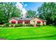 Charming stone home with bright green lawn, red awnings, and mature trees offers nice curb appeal at 508 College St, Bowdon, GA 30108