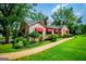 Charming stone home with manicured lawn, red awnings, and mature trees adds to beautiful street at 508 College St, Bowdon, GA 30108