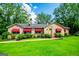 Charming stone home with bright green lawn, red awnings, and mature trees makes great Gathering home at 508 College St, Bowdon, GA 30108