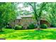 Stone home with mature trees, shrubs, a well-manicured lawn, and a bird bath in the yard at 508 College St, Bowdon, GA 30108
