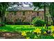 Charming stone home with a well-manicured lawn and colorful flowers in the front yard at 508 College St, Bowdon, GA 30108