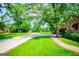 Beautiful landscaped front yard featuring mature trees and a long concrete driveway at 508 College St, Bowdon, GA 30108