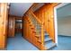 Hallway with wood paneling, carpeted steps, and a traditional wooden banister at 508 College St, Bowdon, GA 30108