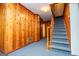 Hallway with wood paneling, featuring a staircase with carpet steps and a wooden banister at 508 College St, Bowdon, GA 30108