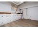 Well-lit laundry room with white cabinets, laminate flooring, and stainless steel fixtures at 508 College St, Bowdon, GA 30108
