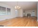Spacious living room with gleaming hardwood floors, neutral paint, fireplace and an elegant chandelier at 508 College St, Bowdon, GA 30108