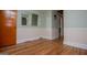 A room with hardwood flooring, neutral wall color, and a modern mirror hanging on the wall at 508 College St, Bowdon, GA 30108