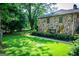 Spacious, green lawn with mature trees and well-maintained shrubbery leading up to stone exterior at 508 College St, Bowdon, GA 30108