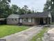 Quaint brick home with an attached carport and a driveway, surrounded by a green lawn at 3929 Rockey Valley Dr, Conley, GA 30288