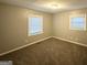 This bedroom is a blank canvas with neutral carpet, two windows letting in natural light, and off-white walls at 3645 Croft Nw Pl, Atlanta, GA 30331