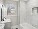 Bright bathroom featuring white marble tiles, a modern vanity, and natural light at 1515 Jonesboro Se Rd, Atlanta, GA 30315