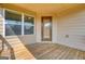 Covered back deck features wood floors, neutral siding and an exterior door at 6665 Flagstone Ct # 918, Cumming, GA 30028