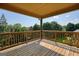 Covered back deck showcasing wood flooring and a beautiful wooded view at 6665 Flagstone Ct # 918, Cumming, GA 30028