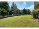 Large, grassy backyard with a privacy fence and mature trees at 6665 Flagstone Ct # 918, Cumming, GA 30028