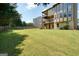 Large, grassy backyard with a two-story home and balconies at 6665 Flagstone Ct # 918, Cumming, GA 30028