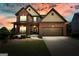 Charming two-story brick home with a covered front porch and manicured lawn at sunset at 6665 Flagstone Ct # 918, Cumming, GA 30028