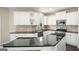 Kitchen features white cabinets, stainless steel appliances, dark countertops, and tile backsplash at 6665 Flagstone Ct # 918, Cumming, GA 30028